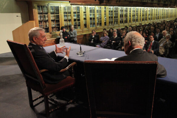 Mario Vargas Llosa en una biblioteca con libros, simbolizando el poder de la lectura y la educación para transformar vidas.