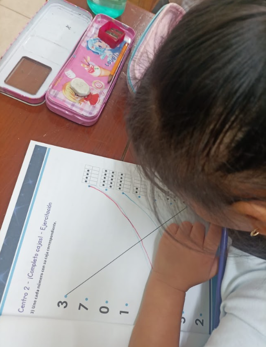 Niña en Yucatán usando materiales didácticos para aprender matemáticas en un aula rural.