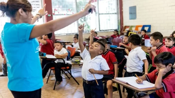 Niñas y niños participan activamente en clase mientras aprenden.