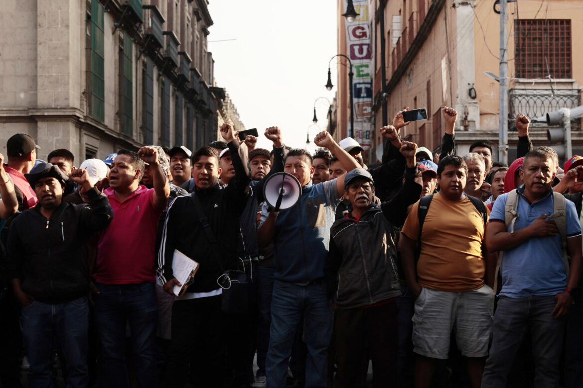 "Maestros de la CNTE protestando en el Zócalo capitalino con pancartas y banderas, reclamando justicia laboral y pensiones dignas."
