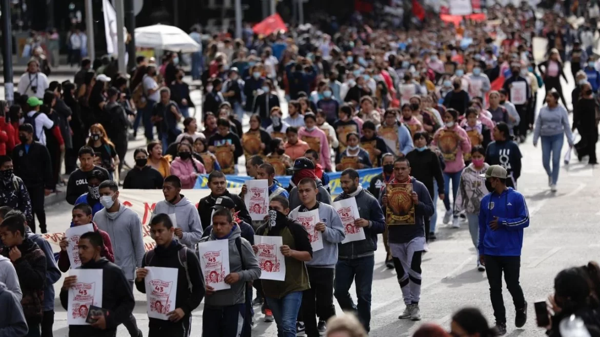 Una multitud de gente marcha por el caso de los 43 estudiantes desaparecidos de Ayotzinapa