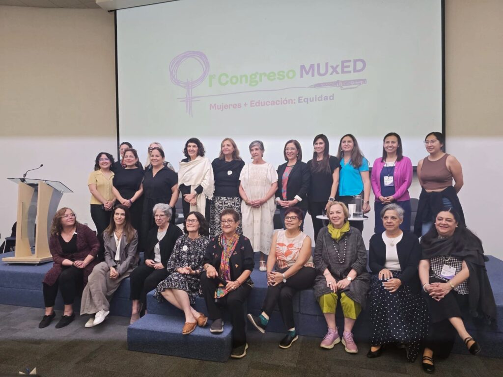 Mujeres reunidas en un congreso, dialogando sobre educación y políticas de género.