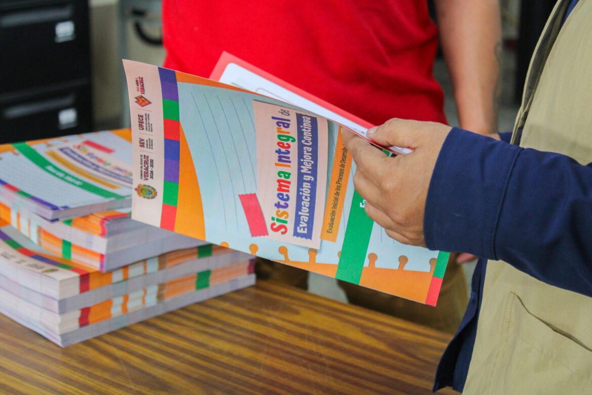 Docente de Veracruz entregando materiales impresos de evaluación diagnóstica a estudiantes de primaria en el aula.